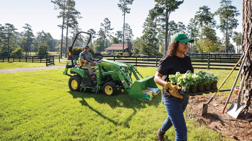 compact utility tractor being used in a residential landscaping setting