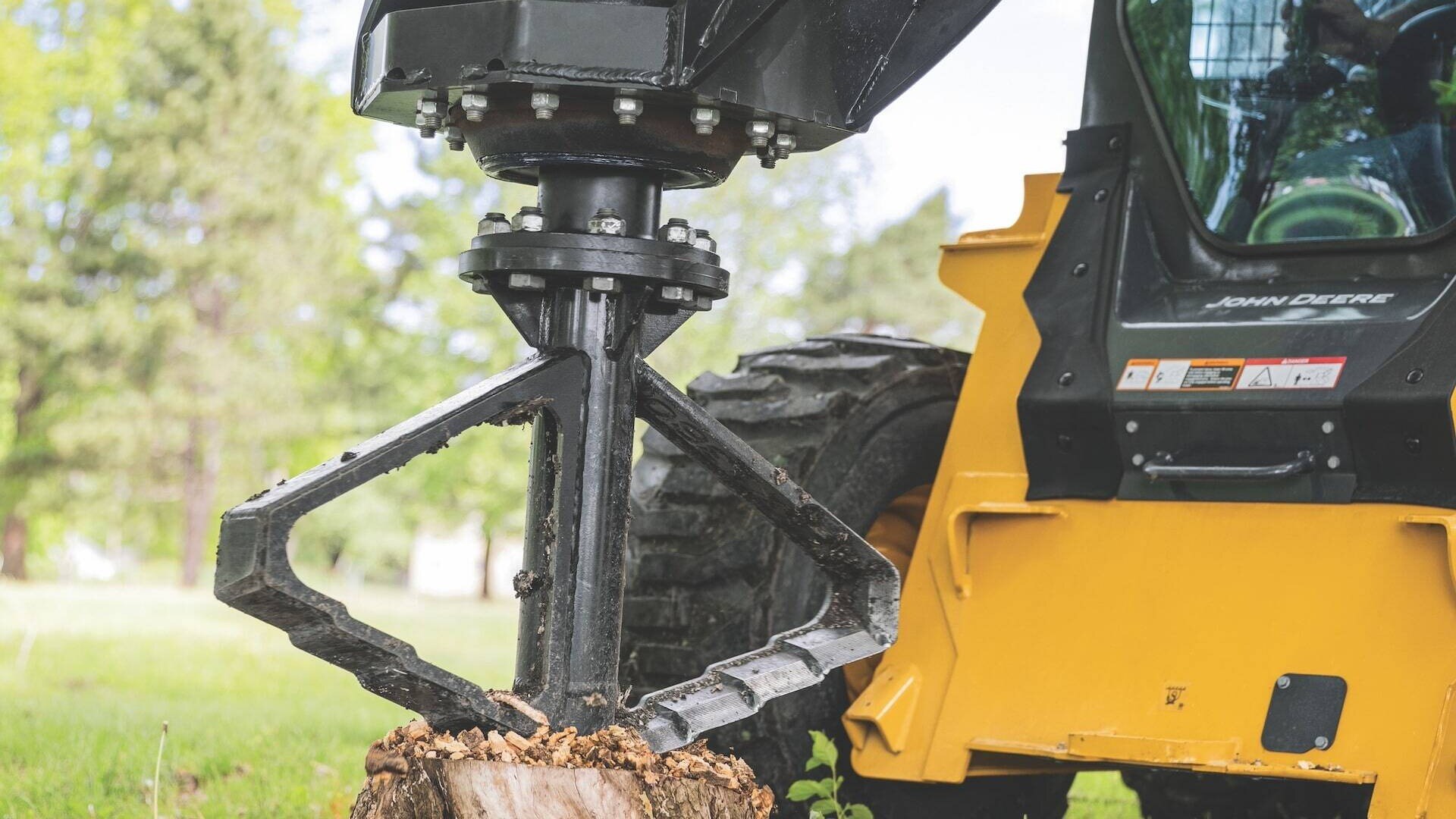 330 P-Tier Skid Steer utilizing an auger to remove a tree stump