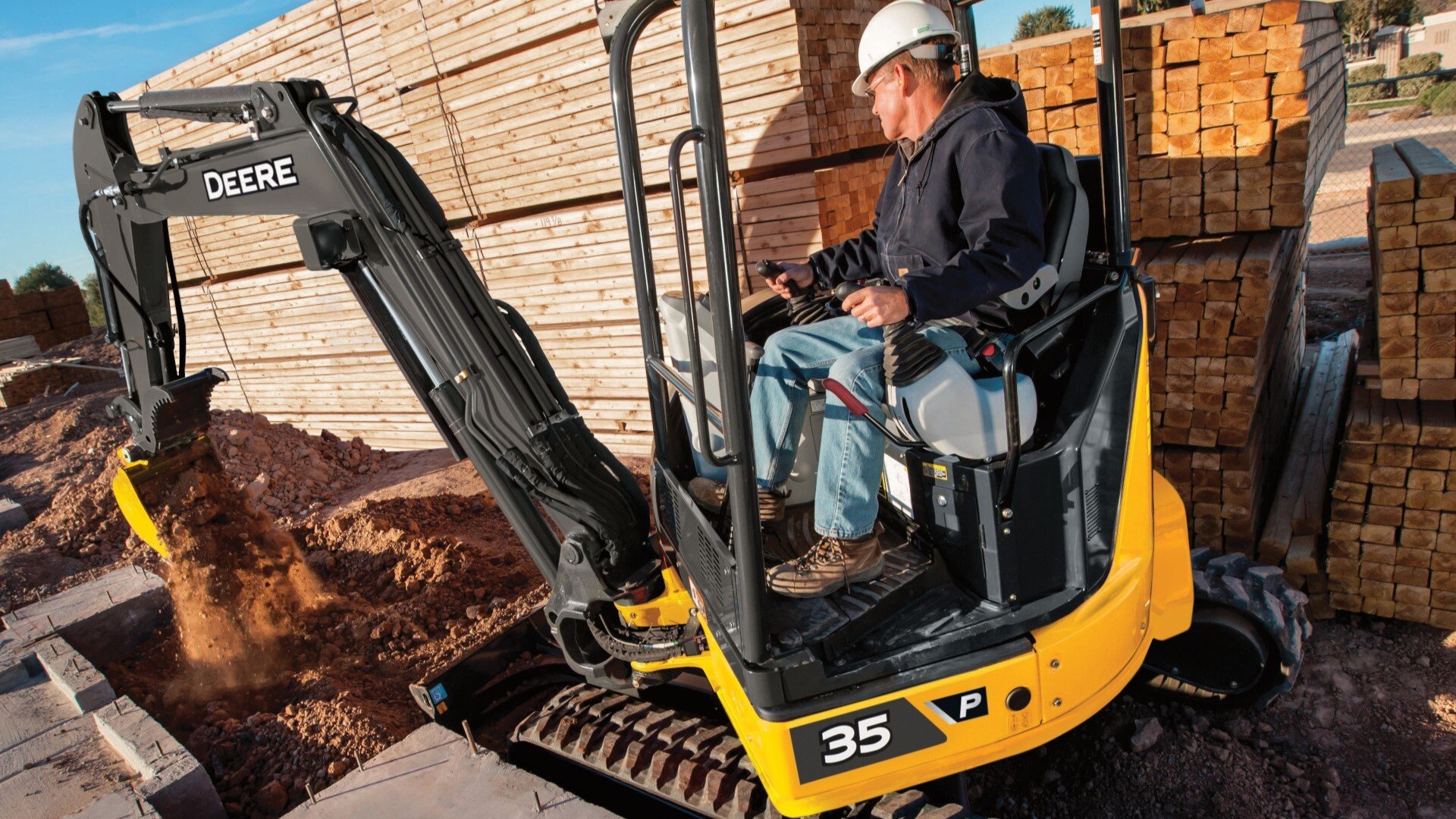 35G John Deere Compact Excavator being used to fill in dirt on a building site