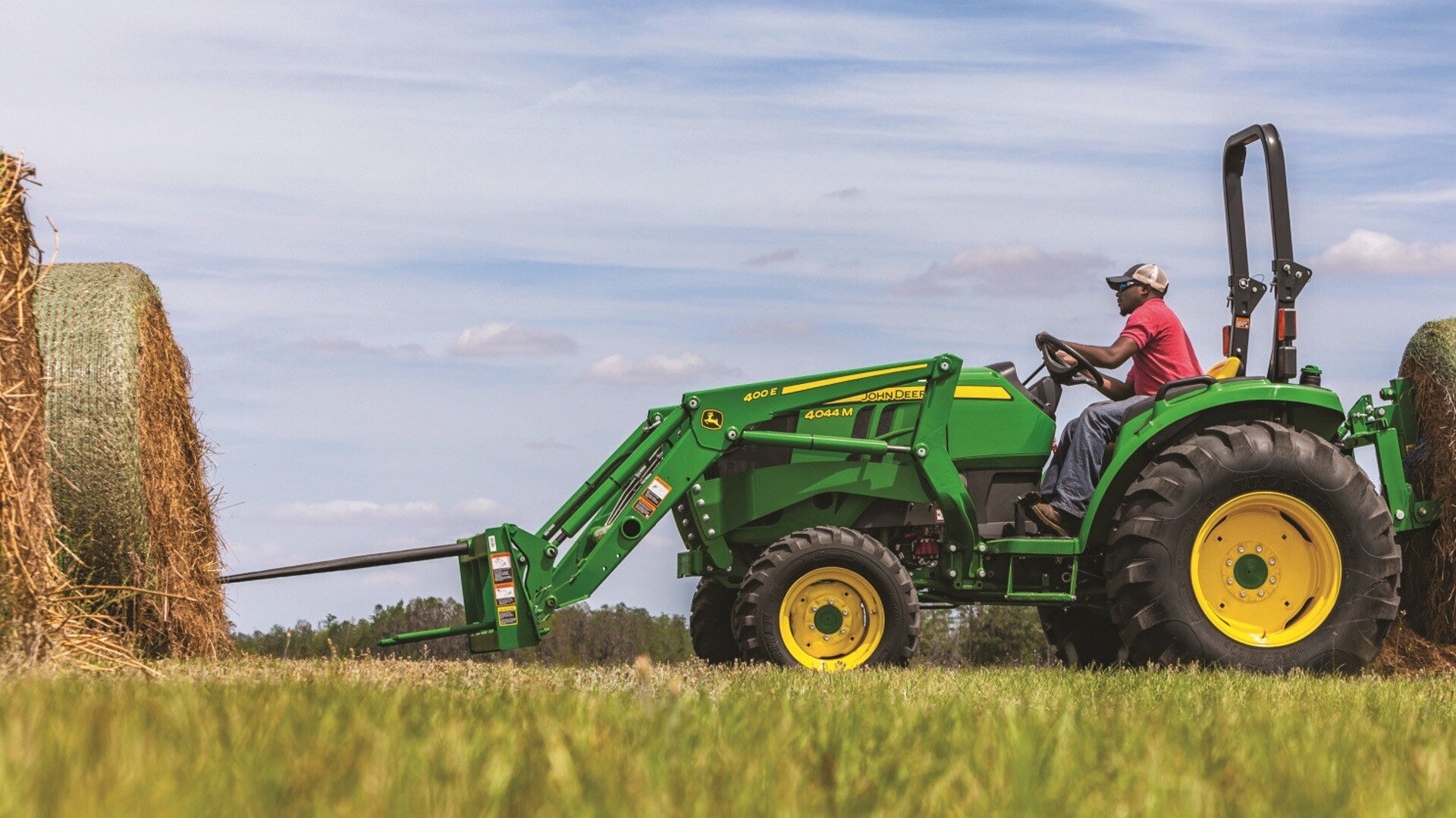 4044M Compact Tractor lifting large bales of hay