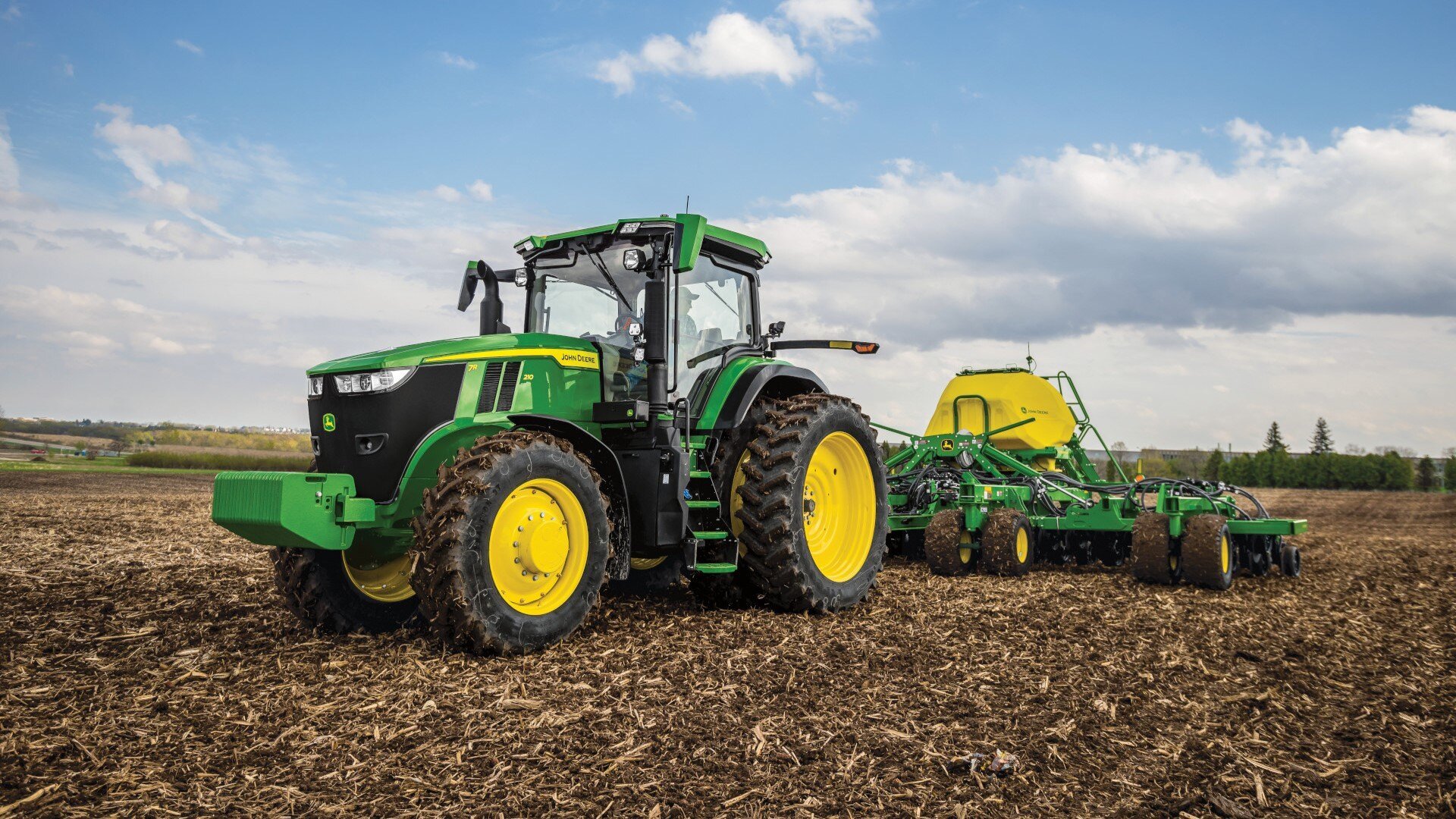 7R Tractor in the field pulling a planter