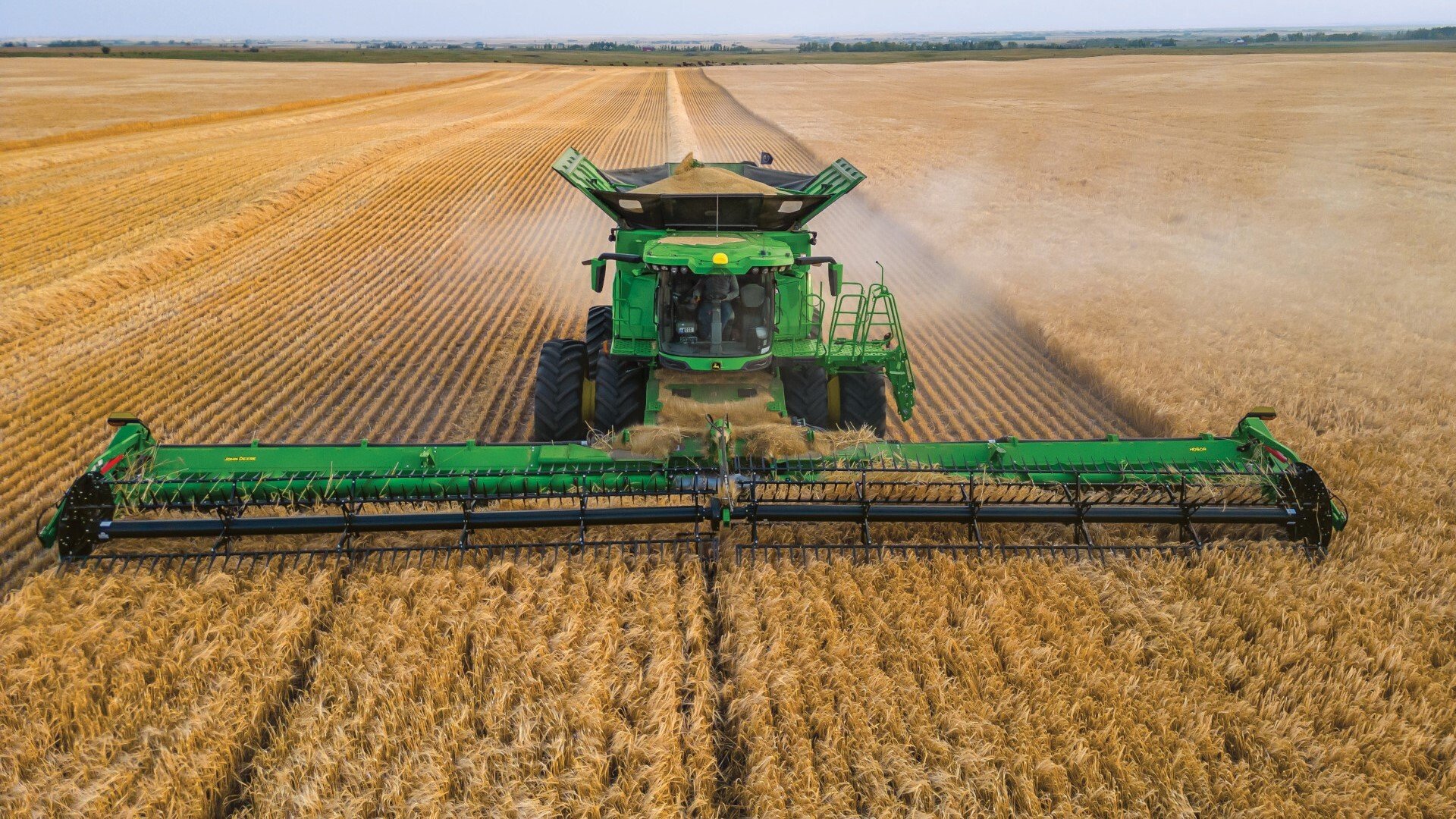 John Deere X9 1000 Combine harvesting large yields of wheat in a field
