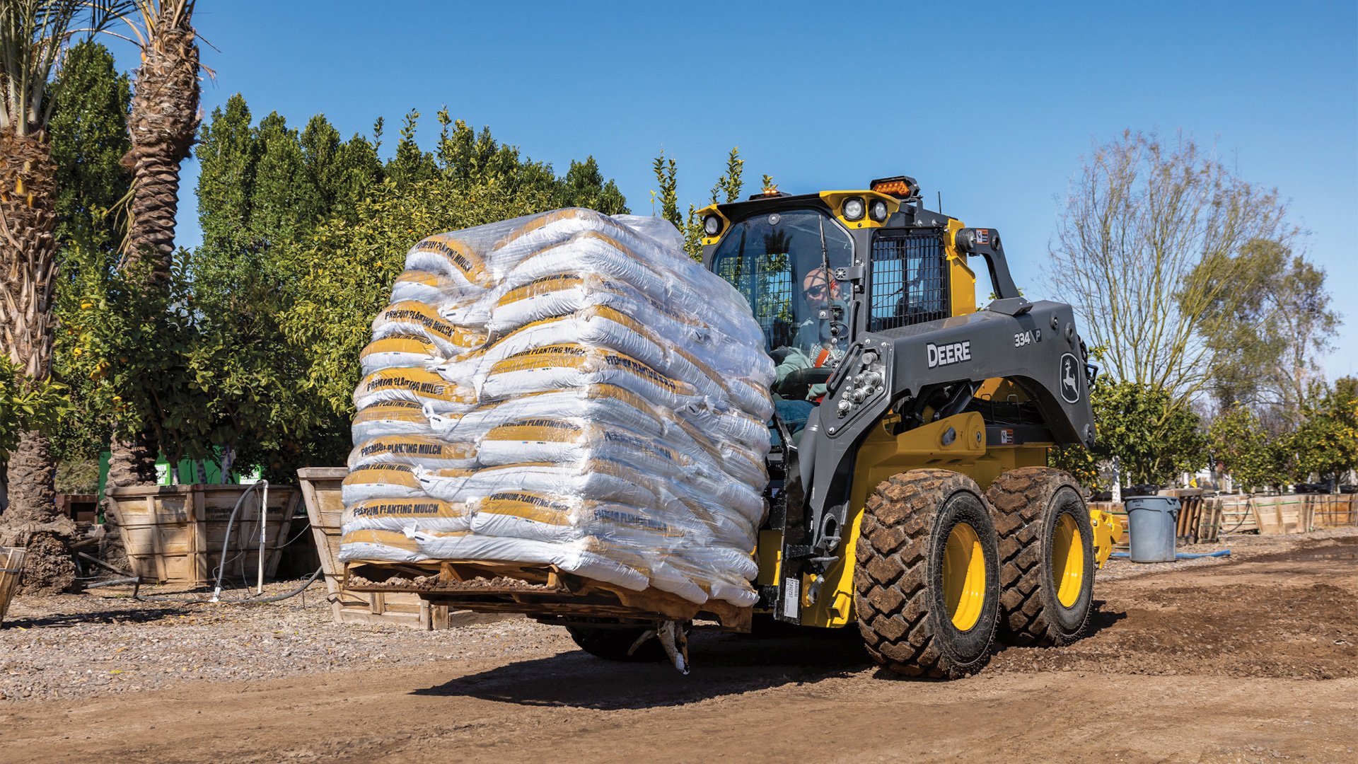 John-Deere-334P-Lifting-a-Skid-at-a-jobsite
