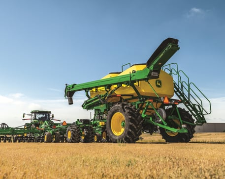 A John Deere 8R 410 tractor working in a field.