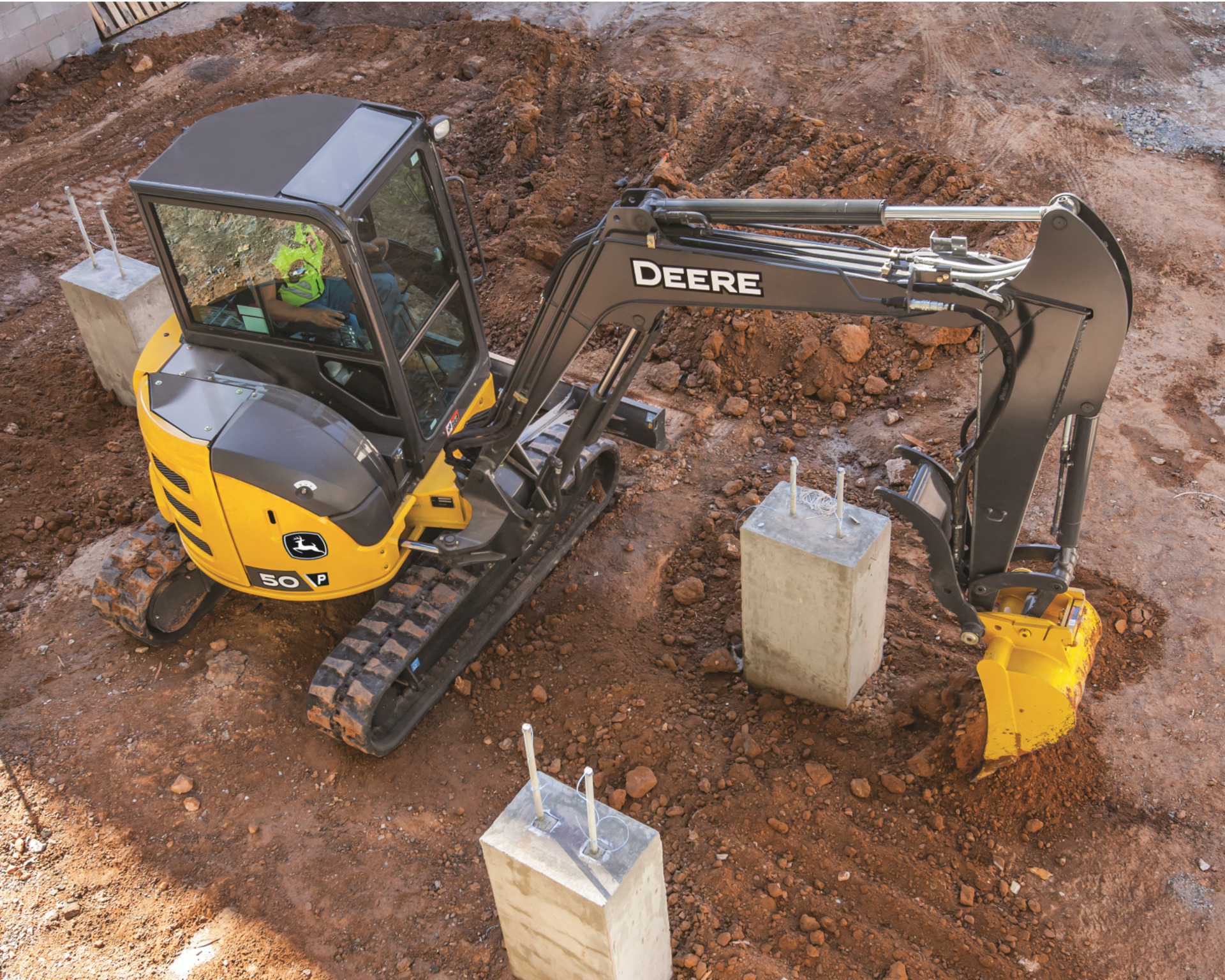 A John Deere 50P works a construction site.