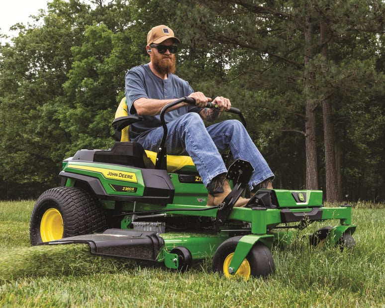 A worker uses a John Deere Z380R to mow their property.