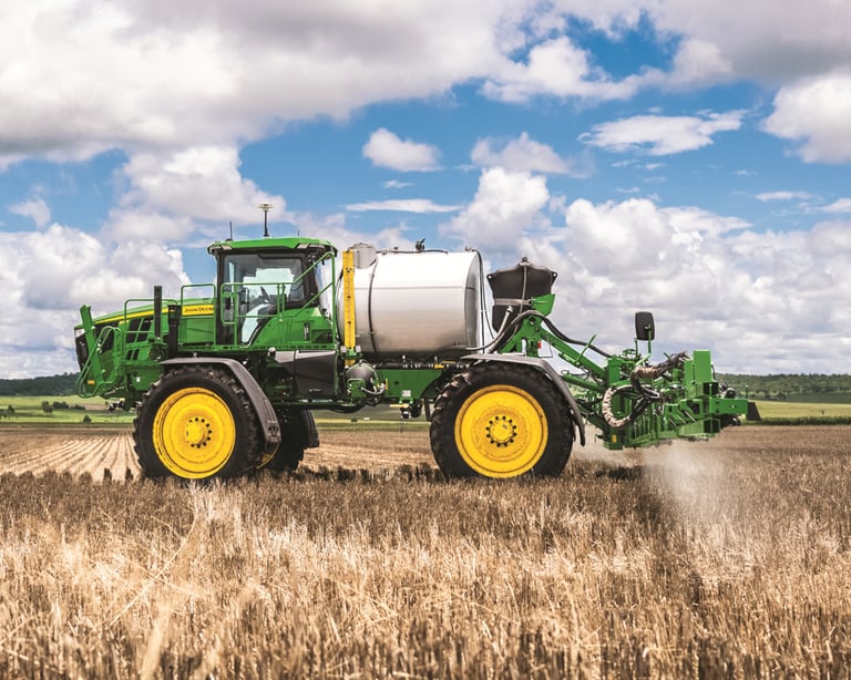 A John Deere sprayer goes over a field.