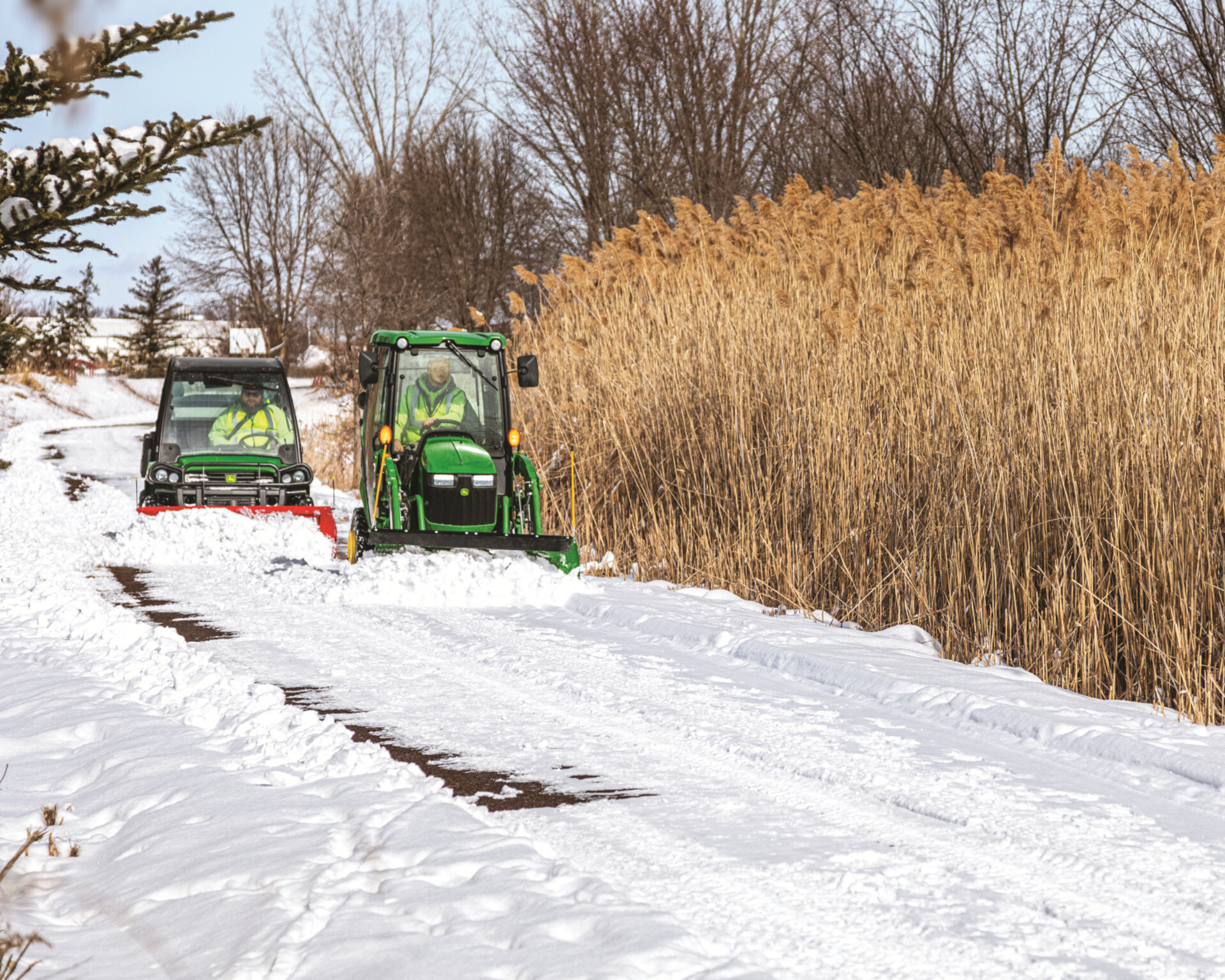 John Deere tractor and Gator in snow.