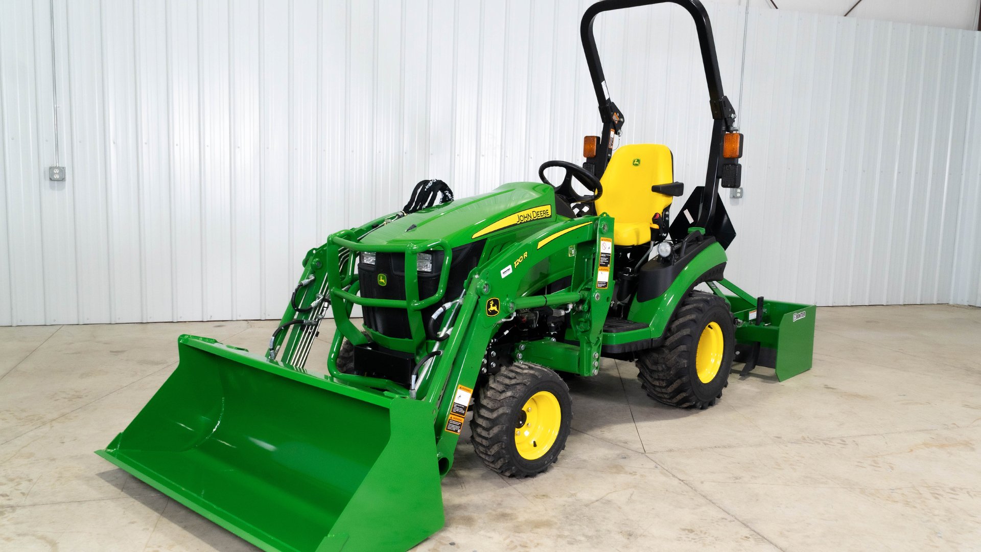 Koenig-John-Deere-1025R-compact-tractor-with-120R-loader-grading-a-gravel-driveway-with-a-box-blade