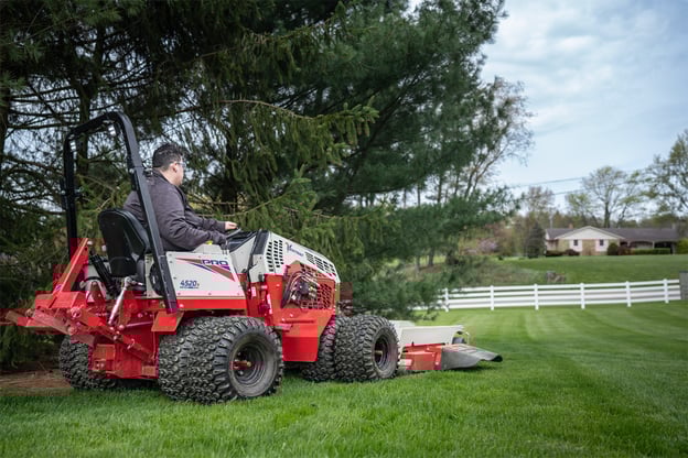 A workers uses a Ventrac 4520N to maintain land on challenging terrain.