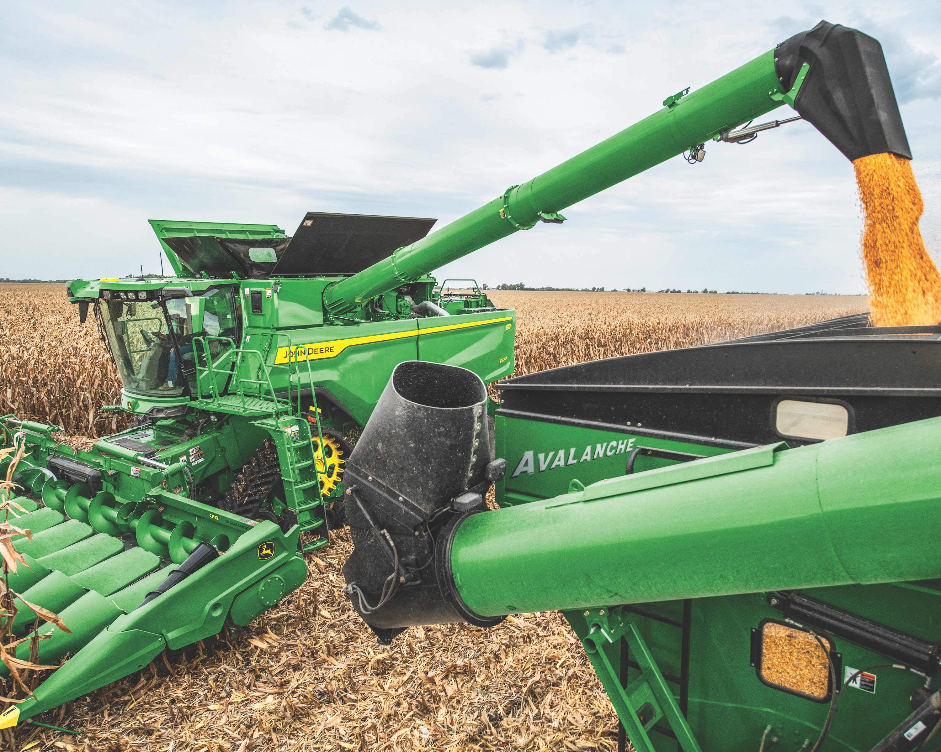 MY25 S7 800 Tracked Combine with Corn Heads dumping corning into a hauler