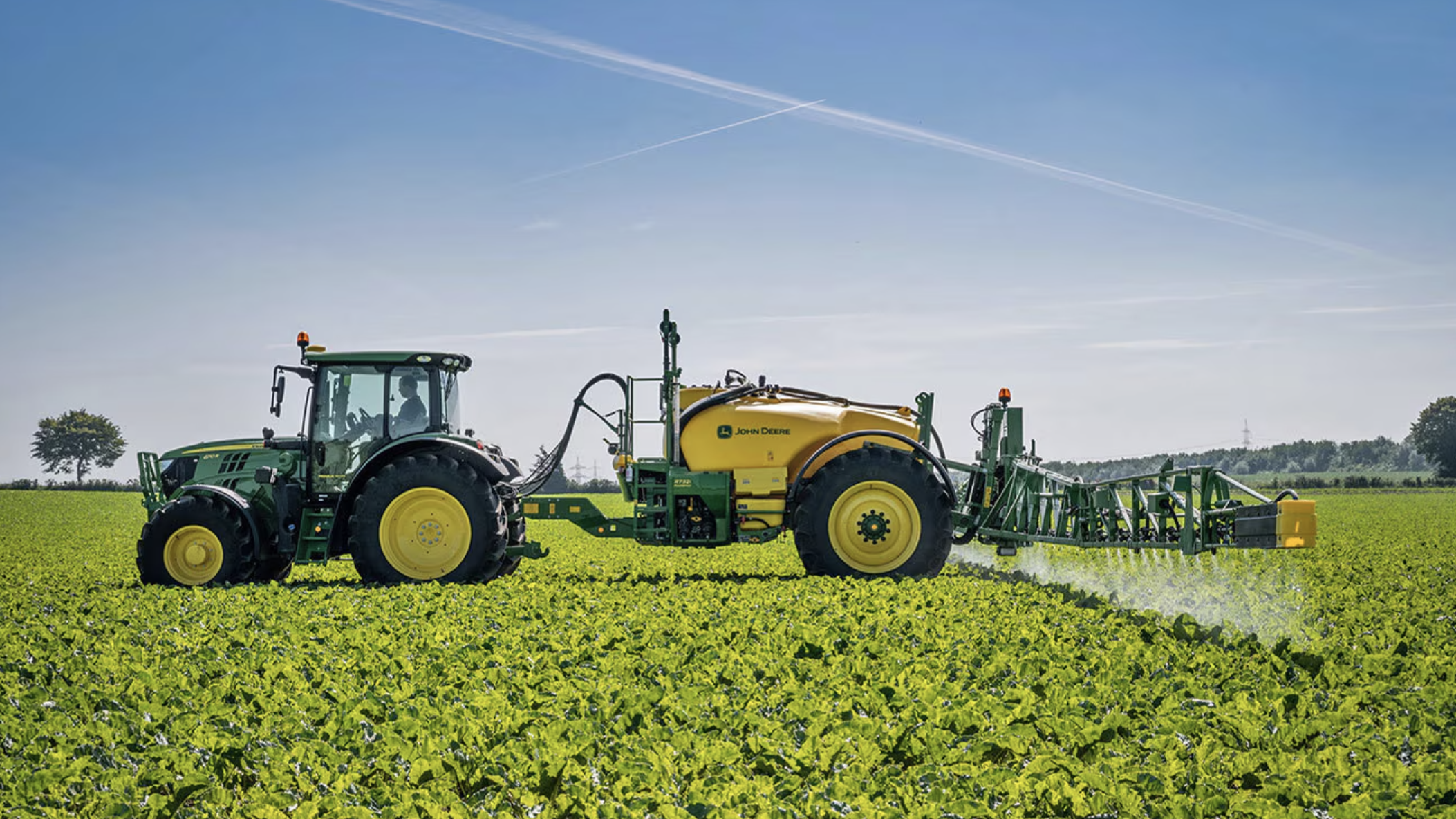 Pull Behind Sprayer in an open field pulled by a john deere tractor