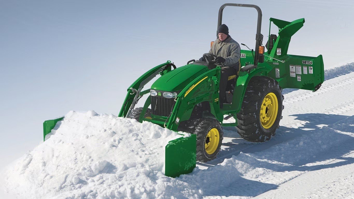 AS10H Series snow pusher removing snow on a clear day.