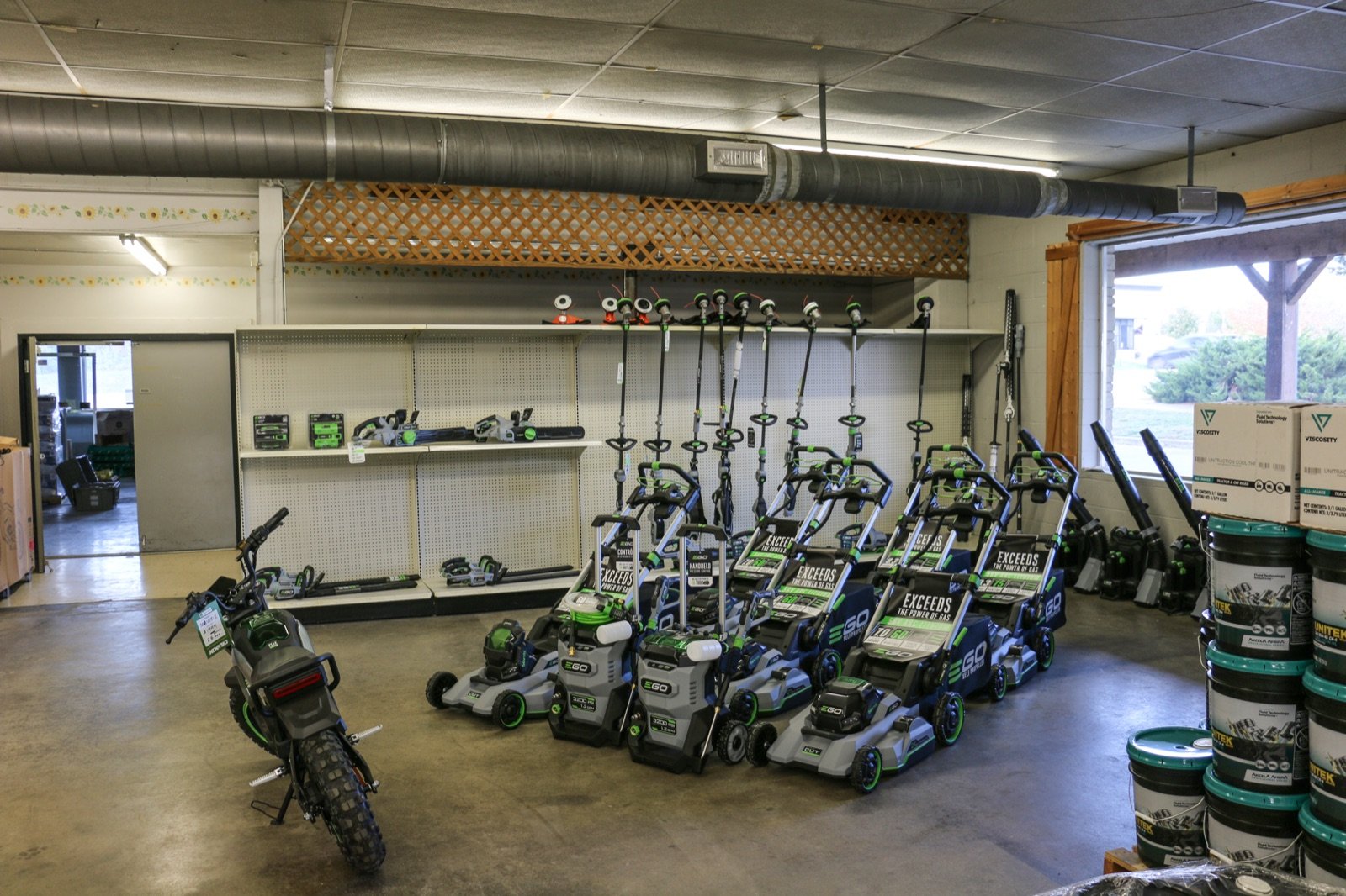EGO Power+ lawn mowers, string trimmers, chainsaws, and leaf blowers are displayed in a retail store.