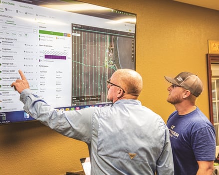 Workers using a John Deere Operation Center precision ag technology.