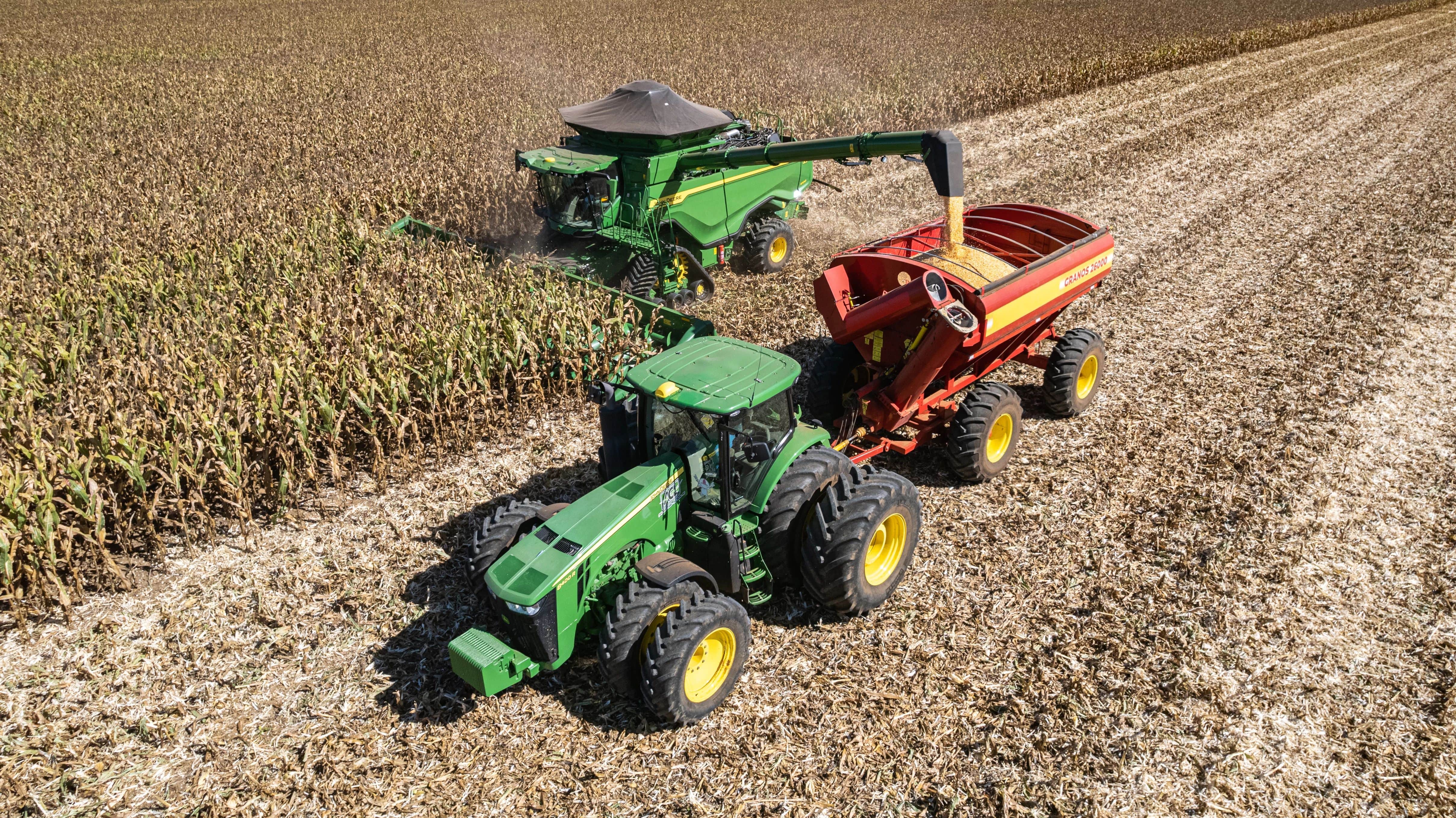 combine and tractor harvesting in a field