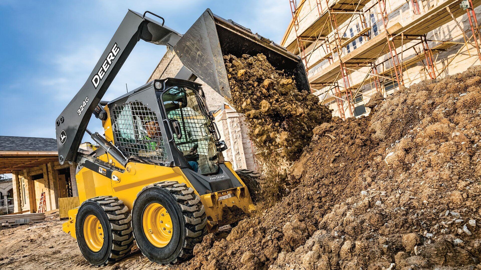 324G John Deere Skid Steer dumping dirt on a construction site